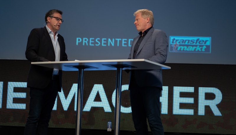 Pit Gottschalk moderiert auf einer Bühne im Gespräch mit Oliver Kahn